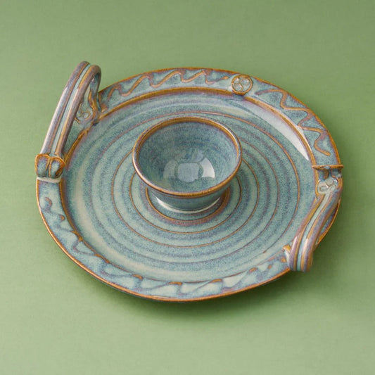 Handcrafted blue and brown glazed pottery dip bowl with handles on a round plate, Kilkenny style