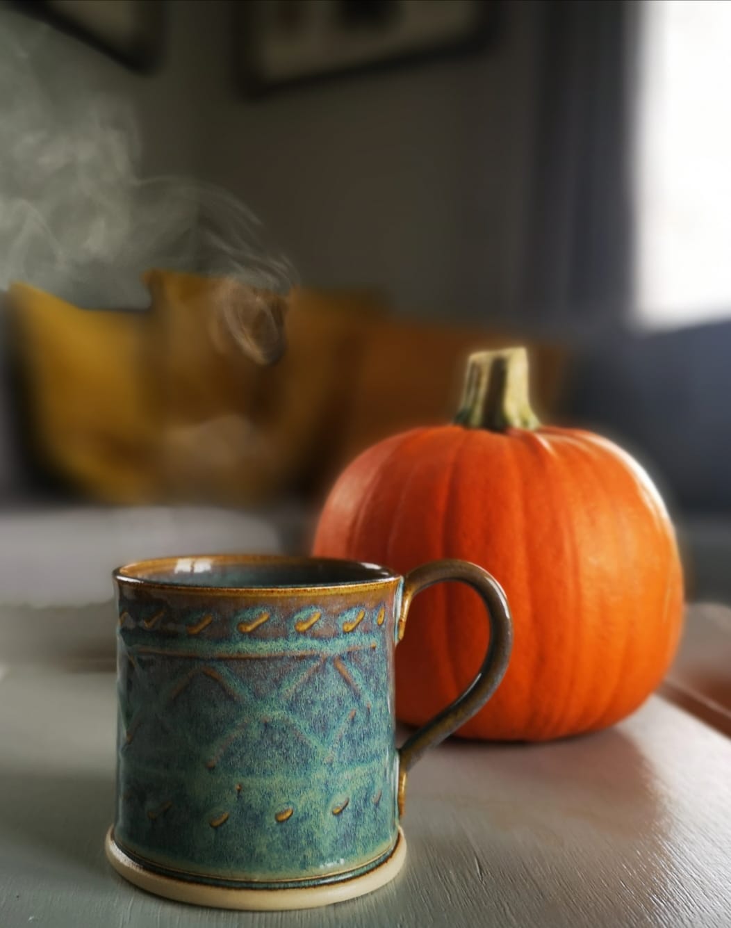 Green Mug with aran knitwear pattern on a table with an orange pumpkin