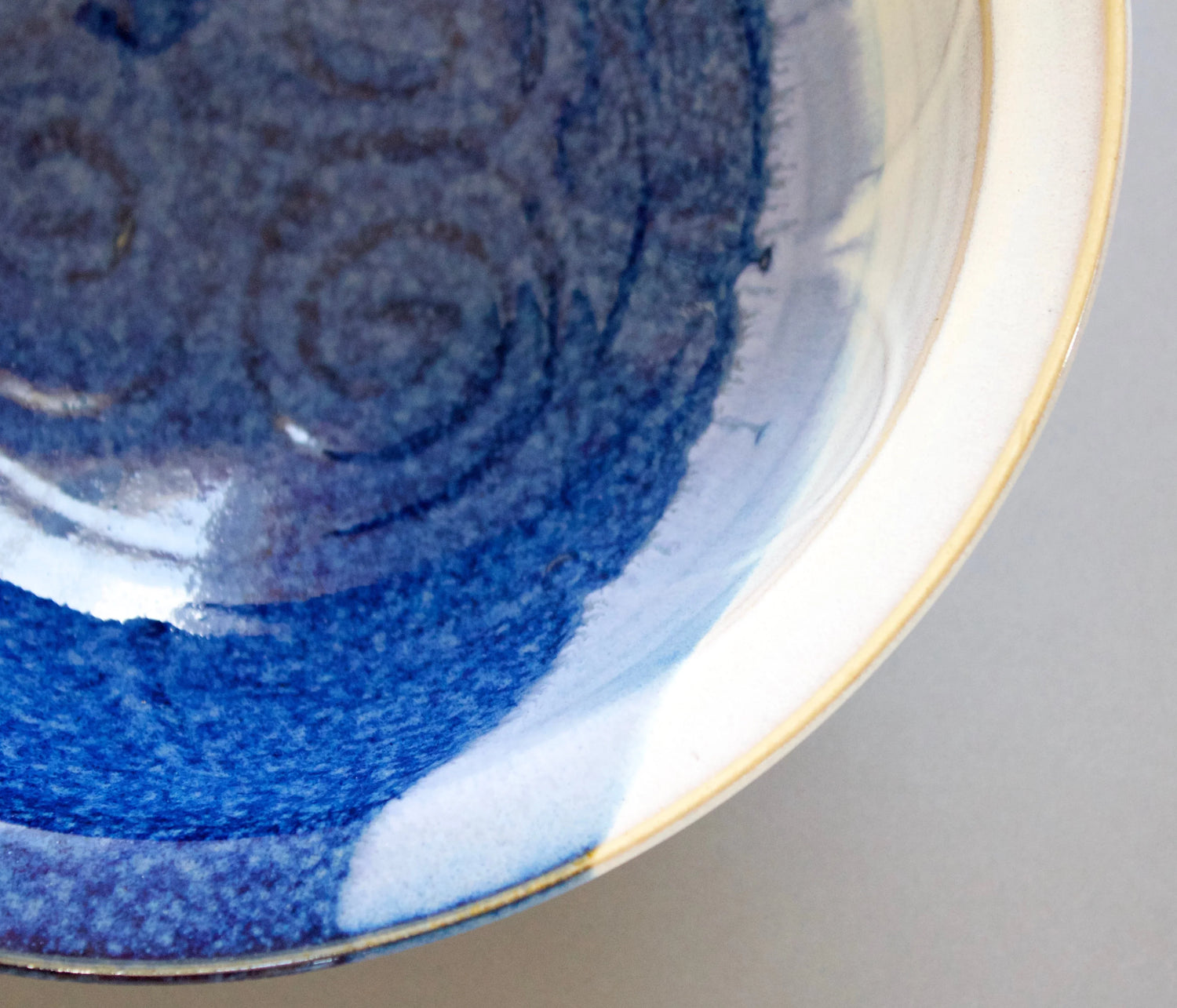 Close-up of ceramic bowl with deep blue glaze and subtle spiral pattern, handcrafted pottery from Kilkenny
