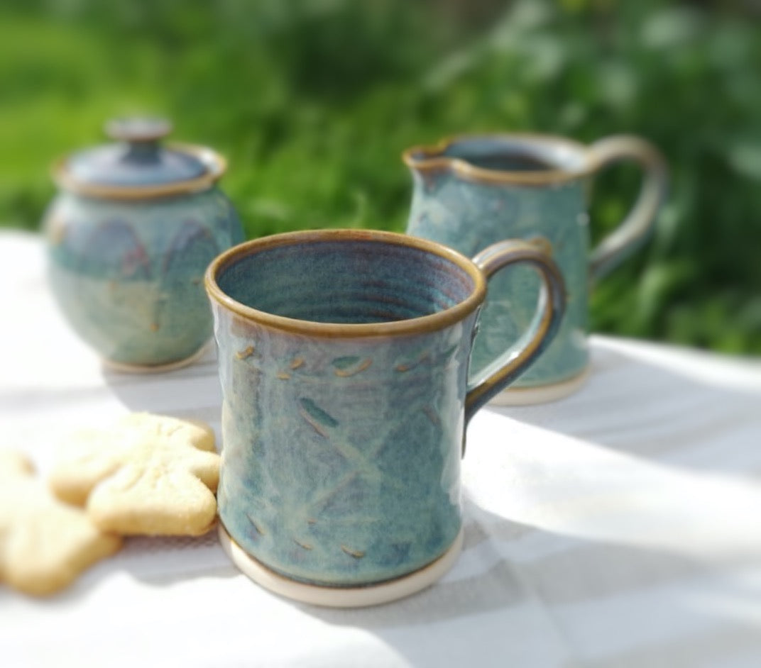 Green Pottery Mug with pattern. Creamer Set on table.handmade by castle Arch Pottery