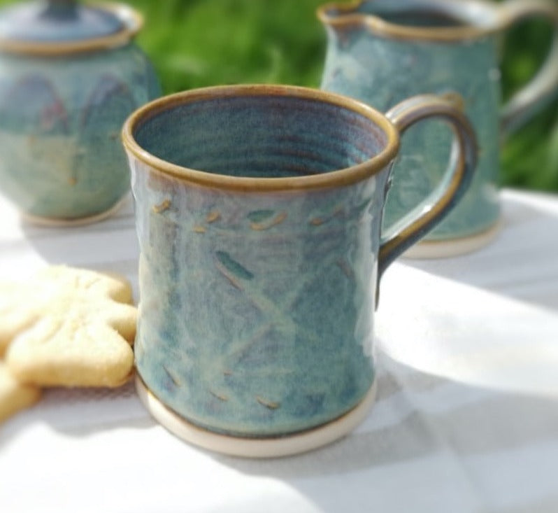 Green Pottery Mug with pattern. Creamer Set on table.handmade by castle Arch Pottery